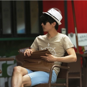 Close-up of a men's Panama style straw hat with a black ribbon and summer outfit details