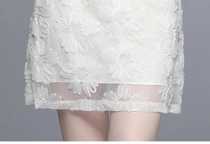Détails de broderie 3D avec paillettes sur le tissu en maille de robe blanche