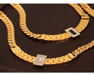 Detail of gold Cuban chain necklace with rectangular shell pendant and paved crystals