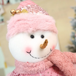 Close-up of a pink sequined Christmas snowman doll with fuzzy fur and a knit scarf