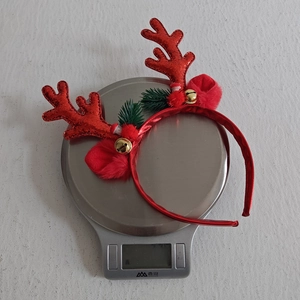 Detail showing Christmas reindeer antler headband weighed at 22.6g on a digital scale