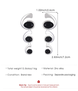 Detailed view of silver spiral drop earrings with black oval stones and size dimensions