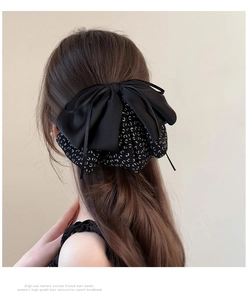 Detail showing back view of large black leopard print bow hair clip on long hair