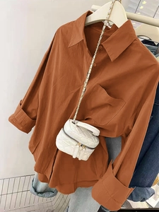 Détail d'une chemise boutonnée caramel avec poche poitrine et poignets retroussés