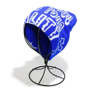 Close-up of royal blue beanie showing white gothic letter jacquard and thick knit texture