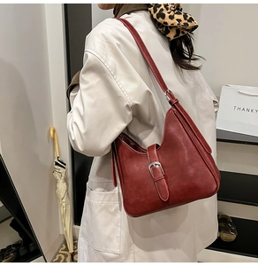 Détail du sac à bandoulière bordeaux vintage avec boucle argentée et fini mat