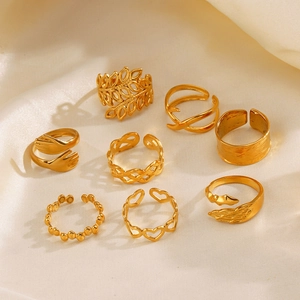 8-piece set of gold bohemian rings with heart, leaf, and wing designs on silk fabric