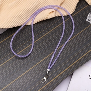Detail eines lila Glitzer-Lanyards mit silbernem Metalldrehhaken auf Holzoberfläche
