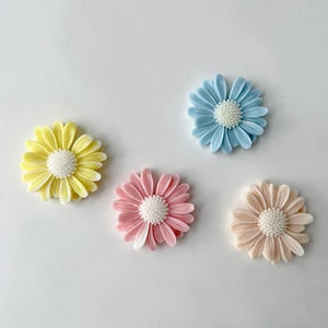 Macro detail of colorful daisy resin charms in yellow, pink, blue and apricot colors