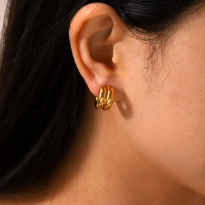 Close-up of 18K gold double-layered chunky hoop earrings on a female model