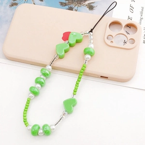 Handmade pearlescent heart beaded phone strap with green and white pearls on pink case