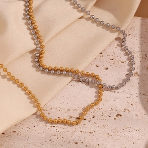 Detail of 4mm bead chain necklaces in gold and silver finish on silk and stone