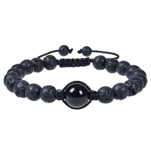 Dettaglio di perle in pietra lavica da 12mm e perla lucida su cinturino nero intrecciato