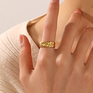 Golden stainless steel wheat ear pattern open ring shown worn on a female finger