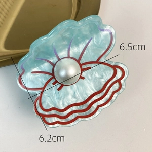 Detail shot of blue shell hair claw with pearl accent showing 6.5cm and 6.2cm sizes