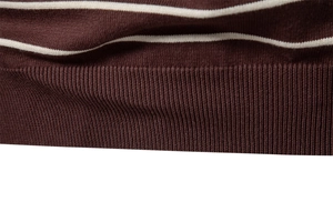 Detail of dark brown knit sweater with white stripes and ribbed cuff texture