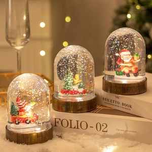 Christmas snow globe decorations with Santa and tree motifs on dark wood bases