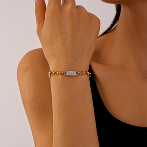 Elegante bracciale a catena bicolore con ciondolo ovale incastonato di cristalli al polso