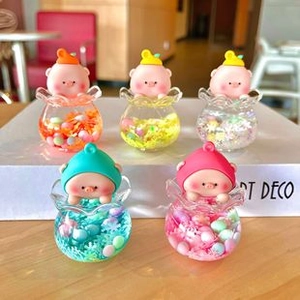 Dettaglio di mini statuette a forma di maialino con sabbie mobili in cinque colori vivaci