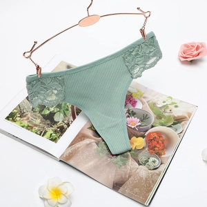 Pale green lace patchwork thong in cotton ribbed fabric on a rose gold hanger