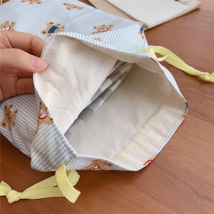 Detail of blue striped bear cotton drawstring bag showing inner lining and capacity