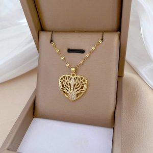 Close-up of a gold hollow heart necklace with clear crystals in a brown jewelry box