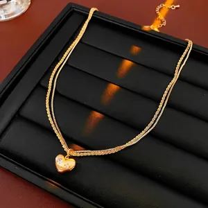 Gold plated double-layered heart pendant necklace with shimmering zircon star accents