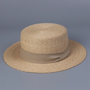 Détail d'un chapeau de paille de raphia haut de gamme avec texture tissée et ruban décoratif