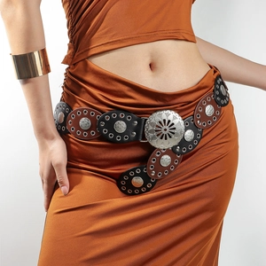 Detail of vintage oval patchwork wide belt with ornate silver buckles on orange dress