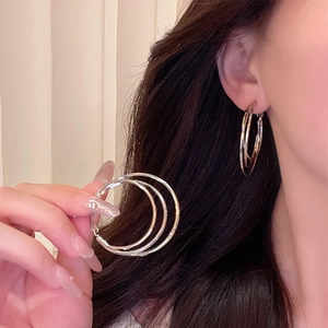 Three-layer silver circle earrings shown on model for elegant minimalist jewelry style