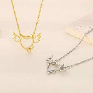 Gold and silver heart necklaces with devil wings and crystal tails in minimalist style