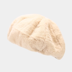 Détail d'un béret en fausse fourrure beige montrant la texture douce et chaude d'hiver