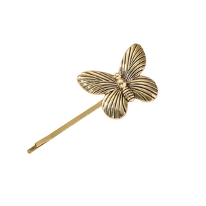 Retro golden butterfly hair clip with detailed vintage metal texture on white background