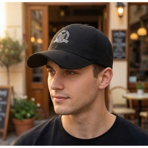 Close-up of vintage black cotton baseball cap with white embroidery and distressed brim detail