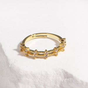 Close-up of gold adjustable ring featuring cross star patterns and zircon inlays