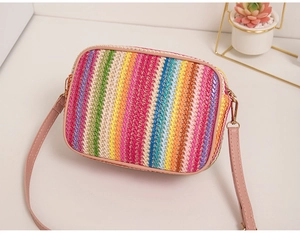 Close-up of rainbow woven crossbody bag with pink strap and clear texture detail