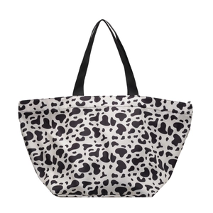 Minimalist cow print canvas tote bag with black shoulder straps on white background