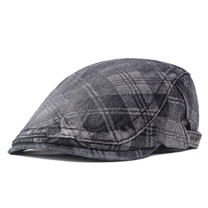 Detail of gray checkered newsboy cap showing textured fabric and adjustable metal buckle