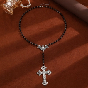 Macro view of gothic black beaded chain with silver bat and cross pendant design