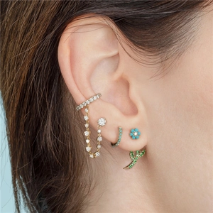 Detail of stacked ear set featuring flower studs and green gemstone drop earrings