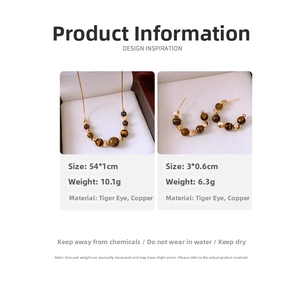 Detail view of 18k gold plated necklace and tiger eye stone earrings in a gift box