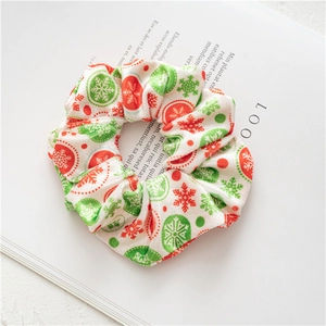 Detailed view of plush Christmas scrunchies with snowflake prints on a magazine