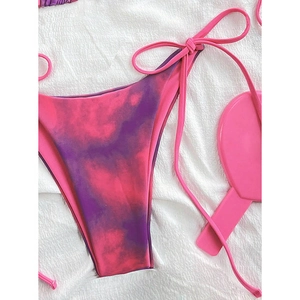 Detail of pink and purple tie-dye bikini bottoms with side ties on textured fabric