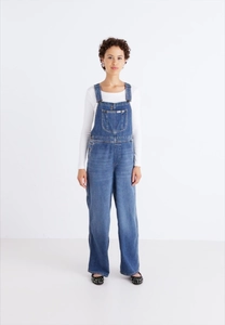 Detailed front view of stylish blue denim overalls with chest pocket on white background