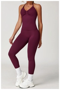 Detail of high-waist fitness leggings in deep magenta with ruched athletic crop top