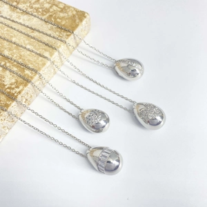 Collier en argent avec pendentif goutte en zircone sur socle en marbre