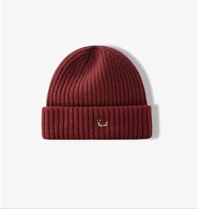Detailed close-up of ribbed texture and cute Corgi embroidery on a dark red knit beanie