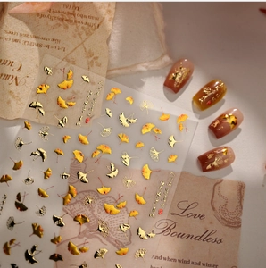 Detailed view of autumn ginkgo leaf nail stickers with gold foil and calligraphy accents
