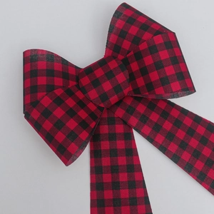 Detailed close-up of a red and black buffalo plaid PVC bow ornament for holiday decoration
