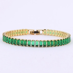 Close-up of gold tennis bracelet with continuous rectangular emerald green zircons